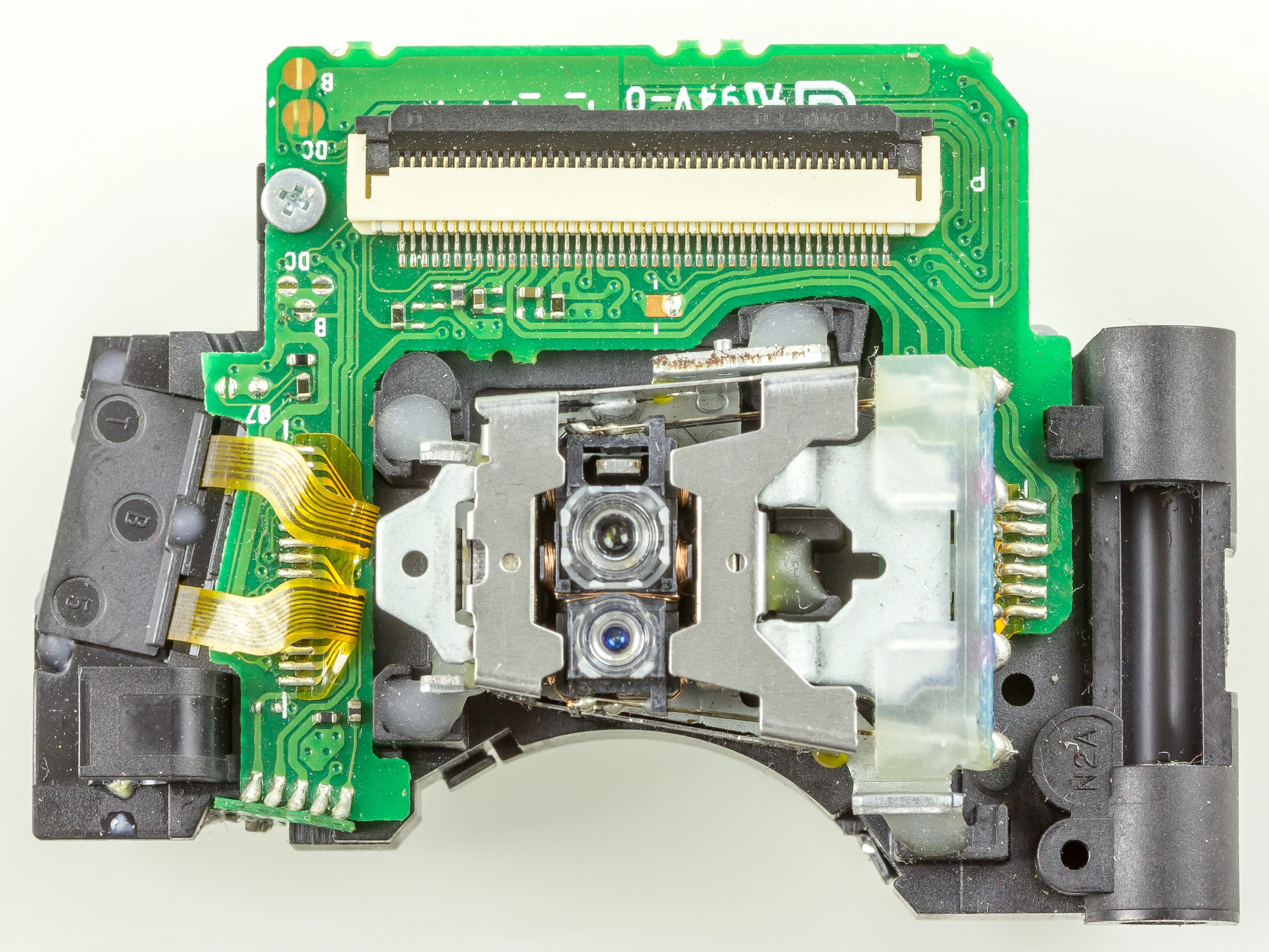 Close-up of the objective lenses and circuit board in an Asatech optical pickup from a Blu-ray reader.